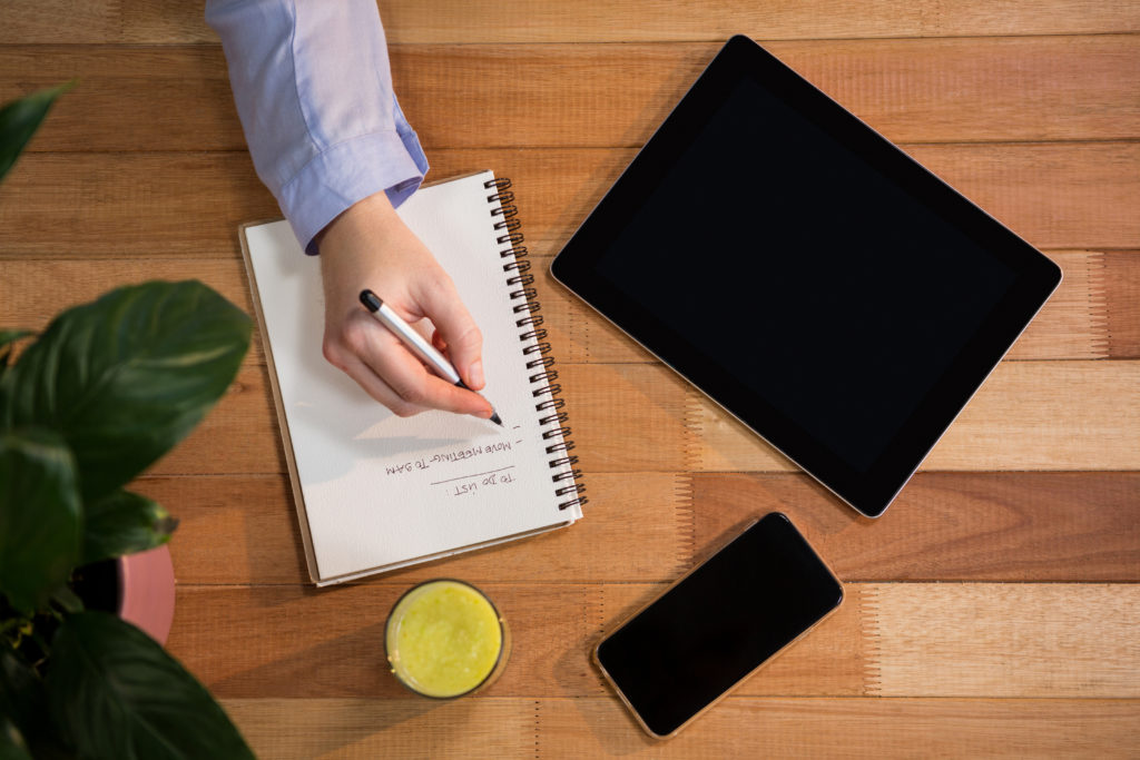 Businesswoman writing in notebook